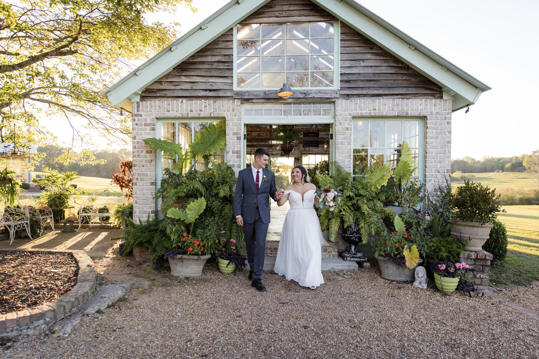Bride and groom portraits in front of the greenhouse at West Milford Farm